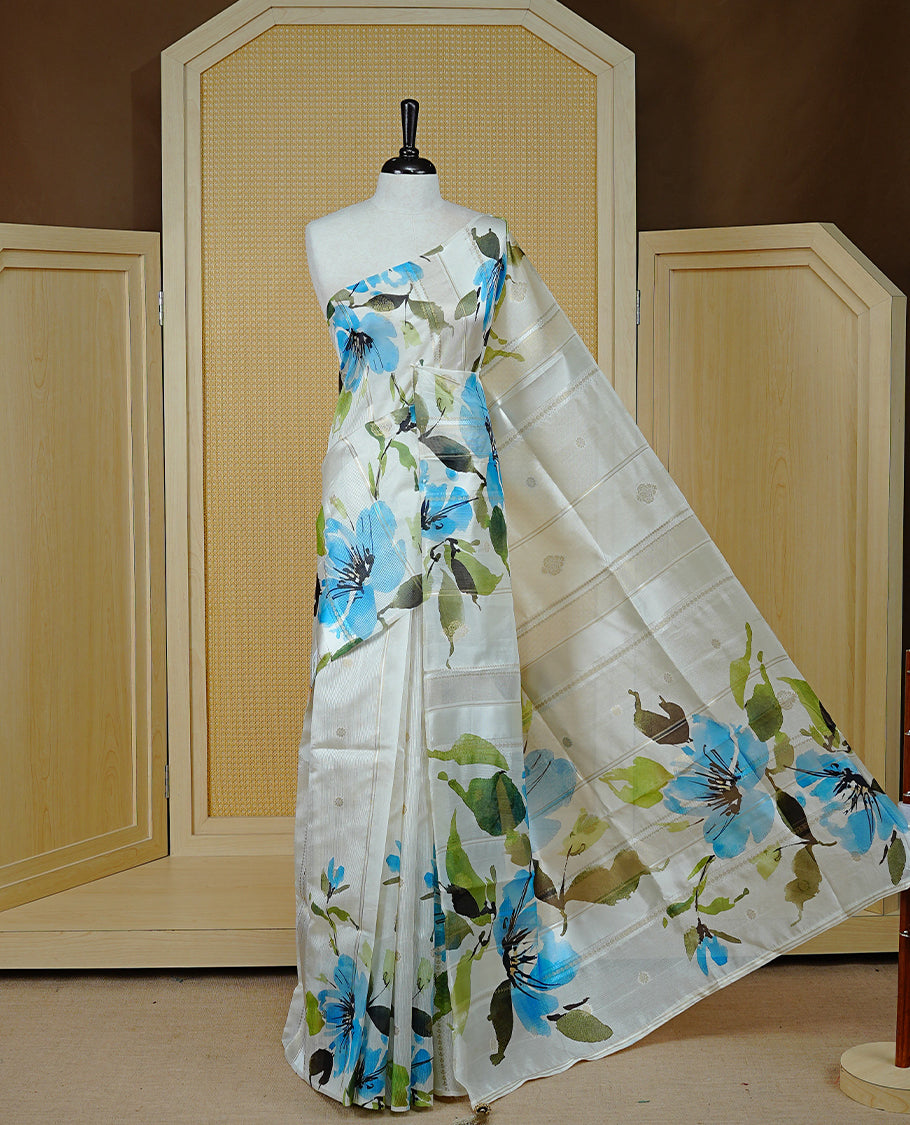 Cream Colour Organza Kerala Saree Featuring Floral Printed Motifs On The Body & Tassels On The Pallu, Paired With A Matching Blouse Piece.
