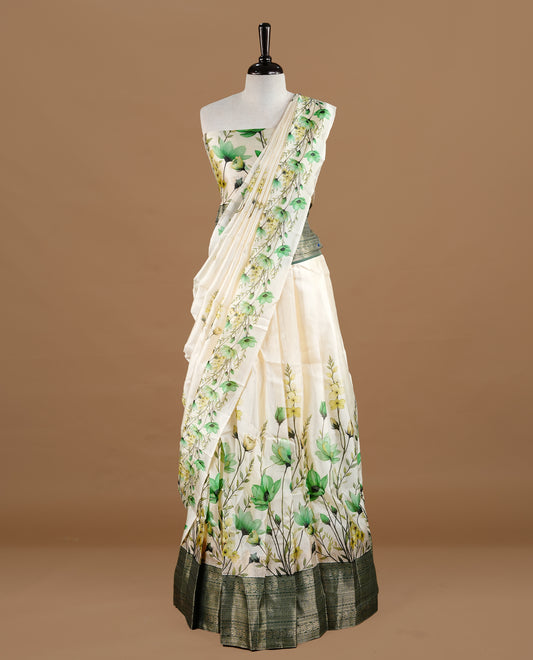 Off white colour semi stitched half saree featuring elegant Green colour floral prints, paired with a contrast green with traditonal zari border and matching printed dupatta ,paired with matching blouse piece.