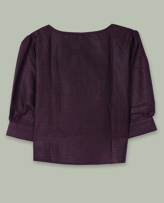 Deep plum three-quarter sleeve top with round neckline and tonal crochet floral appliqués placed at the center front and near the hem