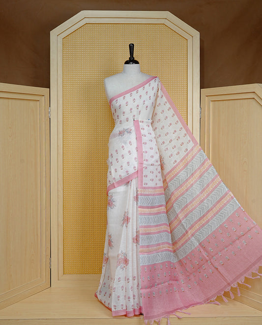Cream colour semi linen saree featuring Floral printed buttas on body, complemented by contrast Peach colour border, comes with matching blouse piece.