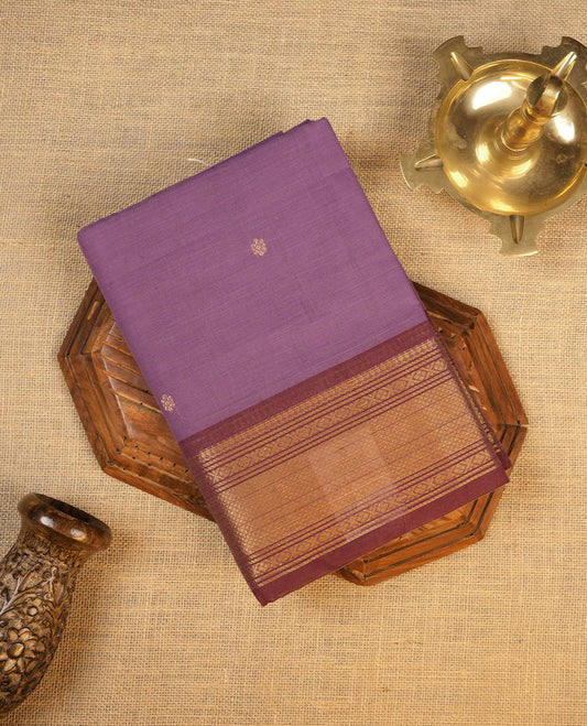 Dark lavender colour chettinad cotton saree featuring small gold zari buttas on body highlighting contrast magenta purple colour with gold zari traditional border, pallu and paired with matching blouse piece.