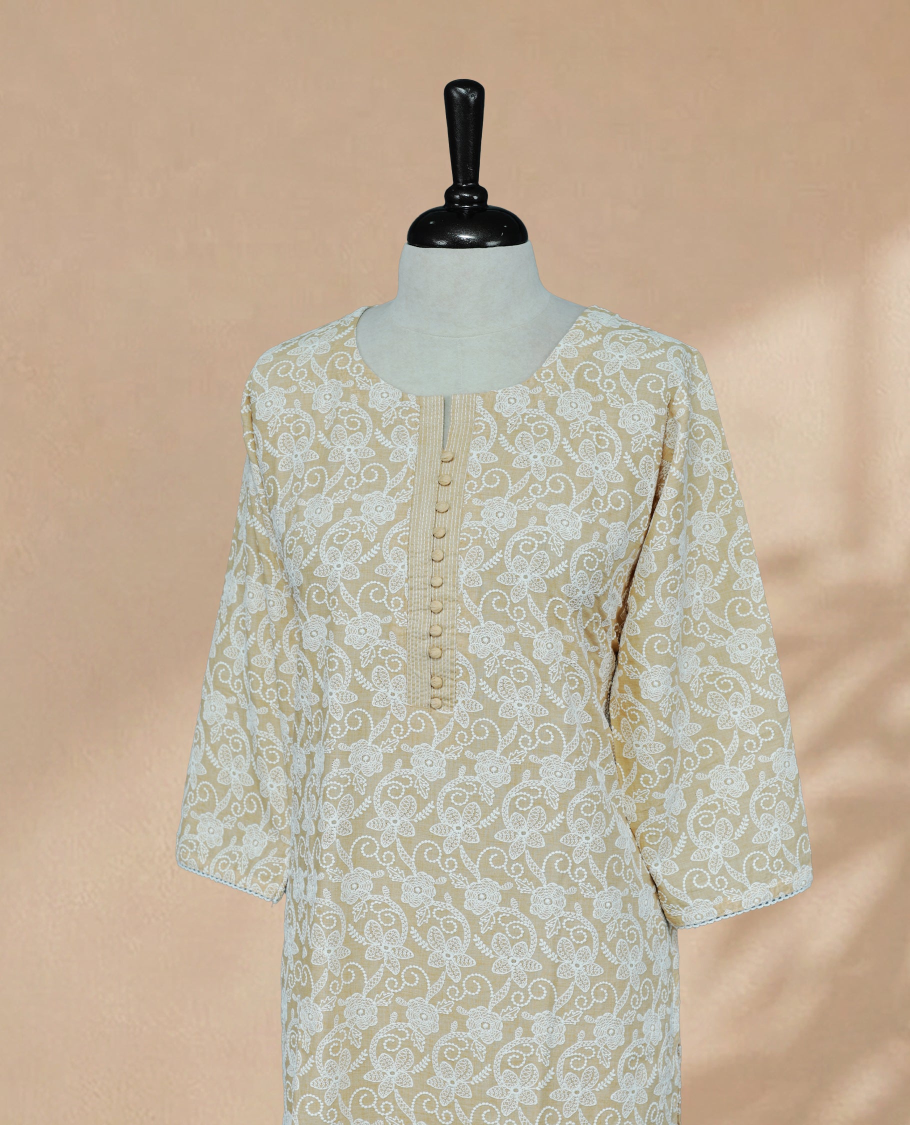 Light Orange Colour kurti featuring a classic U-shaped neckline, White Floral Embroidery Work on the body, and sleeves.