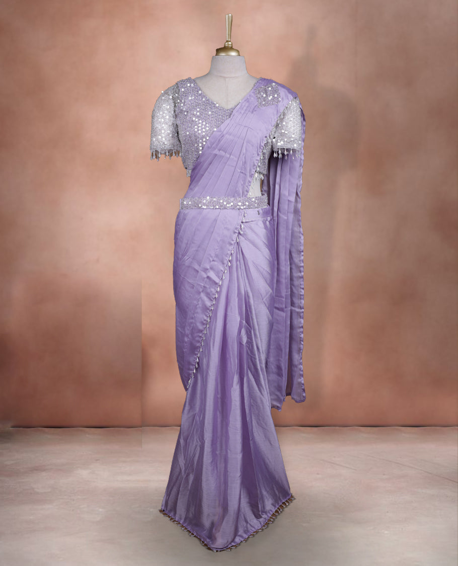Elegant Lavender Colour ready to wear saree adorned with rich silver zari and bead embroidery along the border and pallu, paired with a heavily embellished matching blouse for a grand festive look.