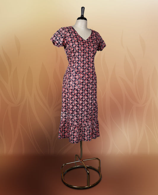 Black colour nightwear adorned with soft pink floral prints, featuring a V neckline, short sleeves, and a flared ruffle hem, A stylish and comfortable choice for daily wear, brunches, or casual outings.