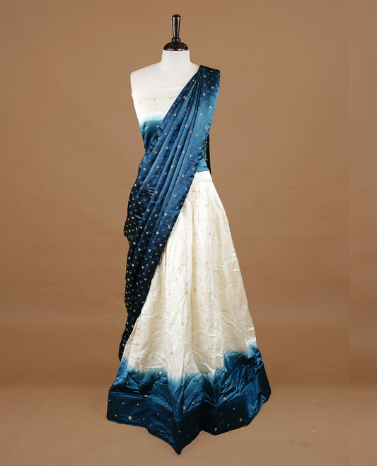 Off White colour half saree material featuring delicate zari buttas on the blouse and skirt, paired with a contrast Teal zari border and matching zari motifs dupatta