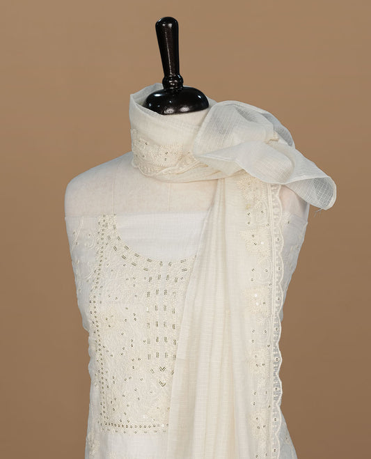 Cream colour churidar material featuring self colour thread and sequins on body and neckline, paired with matching bottom and dupatta.
