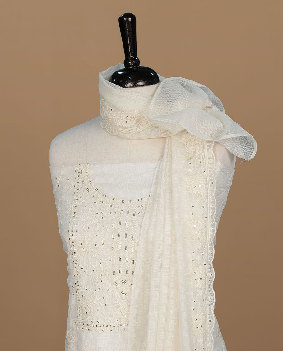 Cream colour churidar material featuring self colour thread and sequins on body and neckline, paired with matching bottom and dupatta.