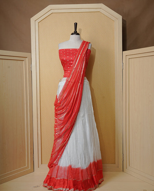 Off white colour Semi stitched dhavani set featuring Gold zari check pattern with contrast Orange border skirt, paired with matching blouse & dupatta.