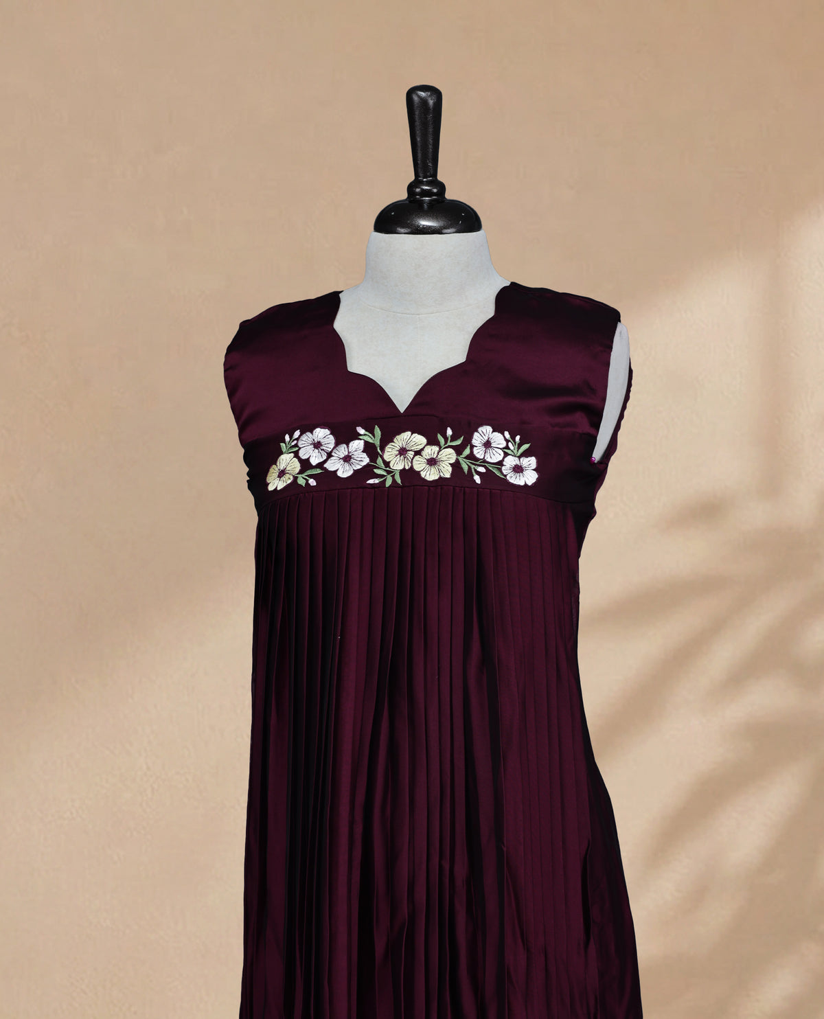 Dark Wine Coloured Sleeveless Kurti Featuring a Designed Neckline, Floral Embroidery on the Body