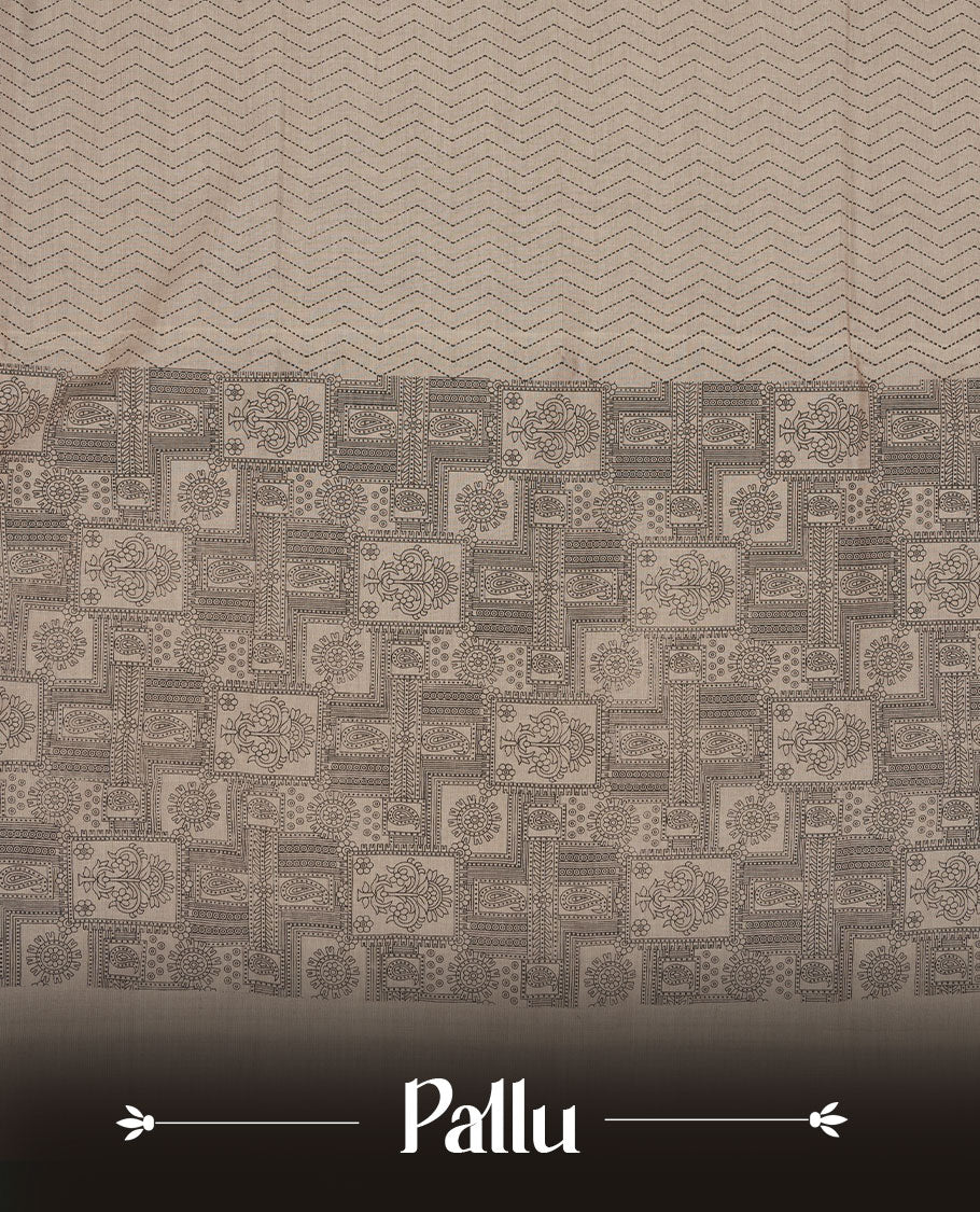 Dark Beige colour poly cotton saree with black zigzag line pattern on the body, paired with a matching pallu featuring black chevron lines and panelled floral‑paisley design, and a coordinated all‑over floral paisley patch‑style printed blouse piece.