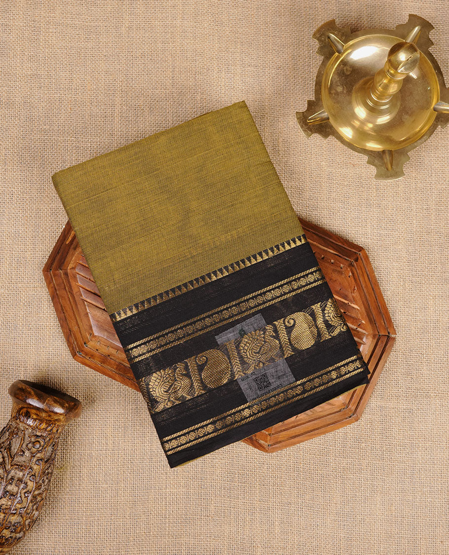 Olive Drab colour chettinad cotton saree featuring plain body, paired with a black colour traditional gold zari border paired with matching blouse.