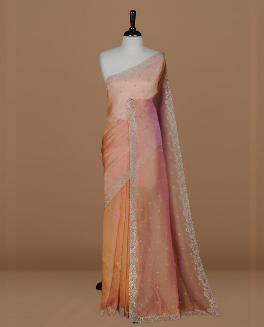 Pinkish orange colour designer saree featuring stone worked body, stone worked border, paired with matching blouse piece.