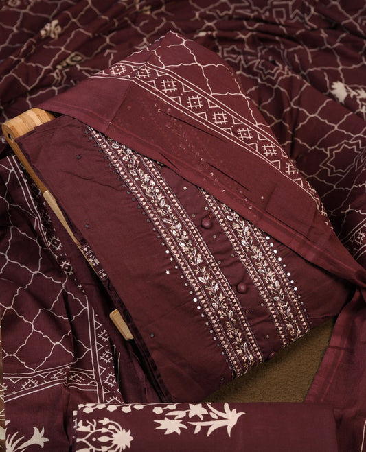 Wine colour churidar material featuring delicate thread embroidery with mirror work on the front panel, paired with a printed dupatta and matching bottom.