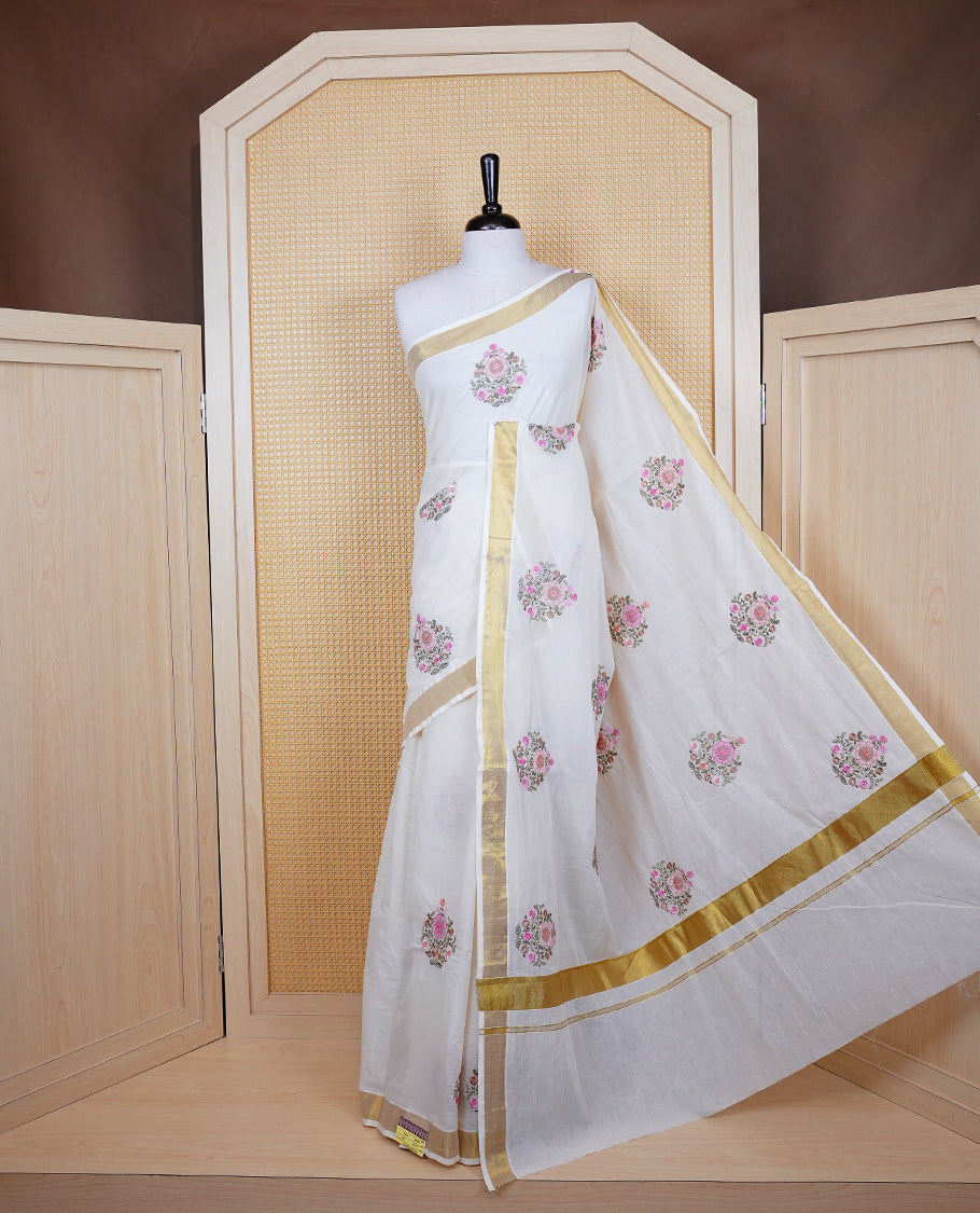 Cream colour cotton Kerala saree featuring Floral Thread work buttas body, complemented by gold kasavu Border, comes with matching blouse piece.