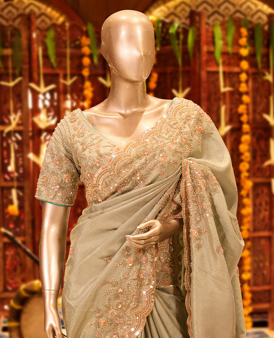 Sage Green colour tissue organza designer saree featuring delicate embroidery and beadwork across the body, finished with heavy embellished border and pallu, paired with a matching tissue organza designer readymade blouse.
