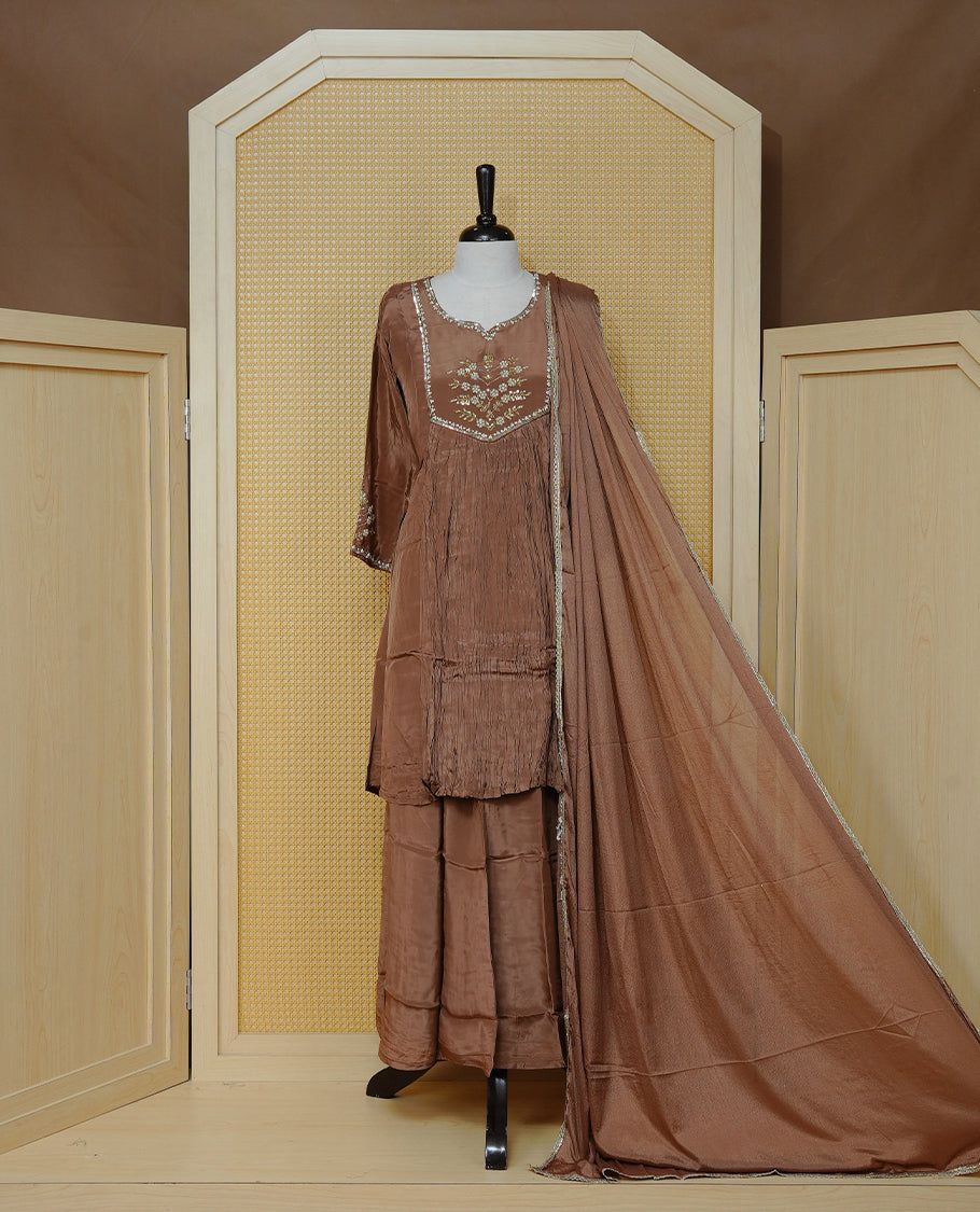 Pastel brown colour churidar set with bead and sequin floral embroidery on the yoke, a delicately embellished neckline and sleeve cuffs, paired with a matching bordered dupatta and solid pants.