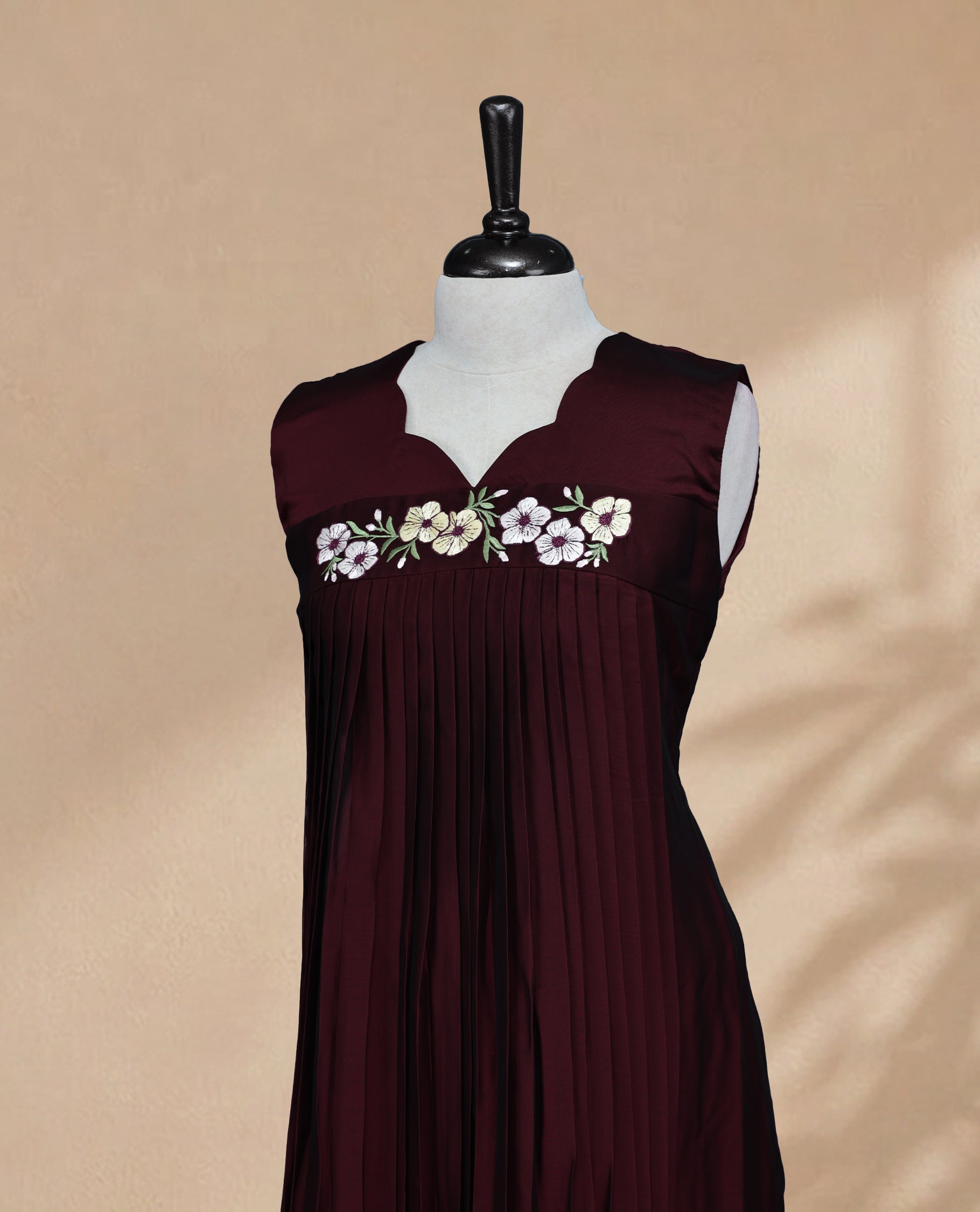 Dark Maroon Coloured Sleeveless Kurti Featuring a Designed Neckline, Floral Embroidery on the Body
