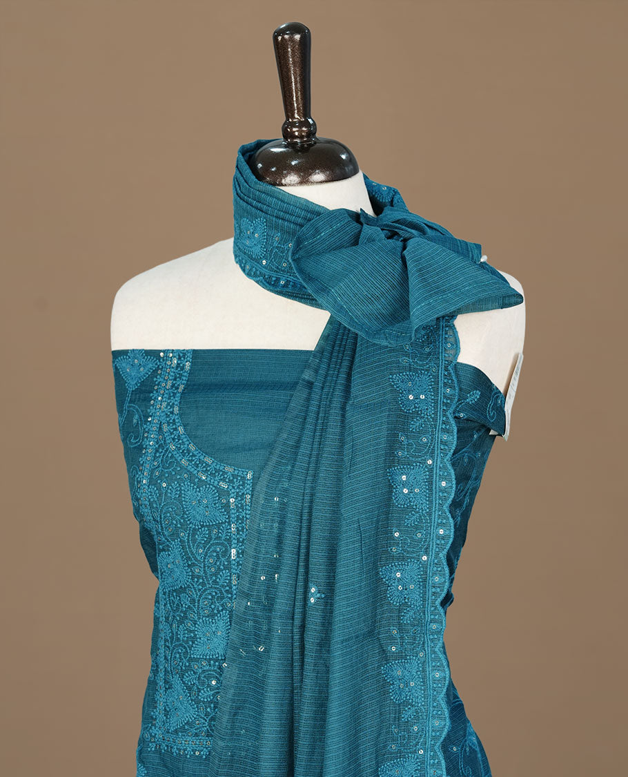 Teal  colour churidhar material featuring self colour thread and sequins work on body, paired with matching bottom and Dupatta.