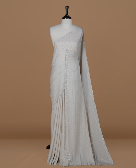 Grey colour designer saree featuring white stone stripes on body, highlighting white stone with scalp border, paired with matching blouse piece.