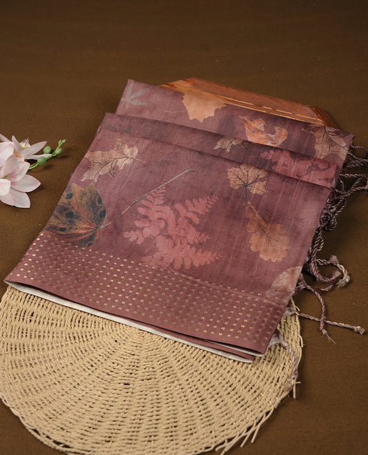 Brown colour tussar saree featuring woven Eco leaves printed on the body, complemented by a self colour gold zari bindi butta border & pallu, paired with a matching blouse.