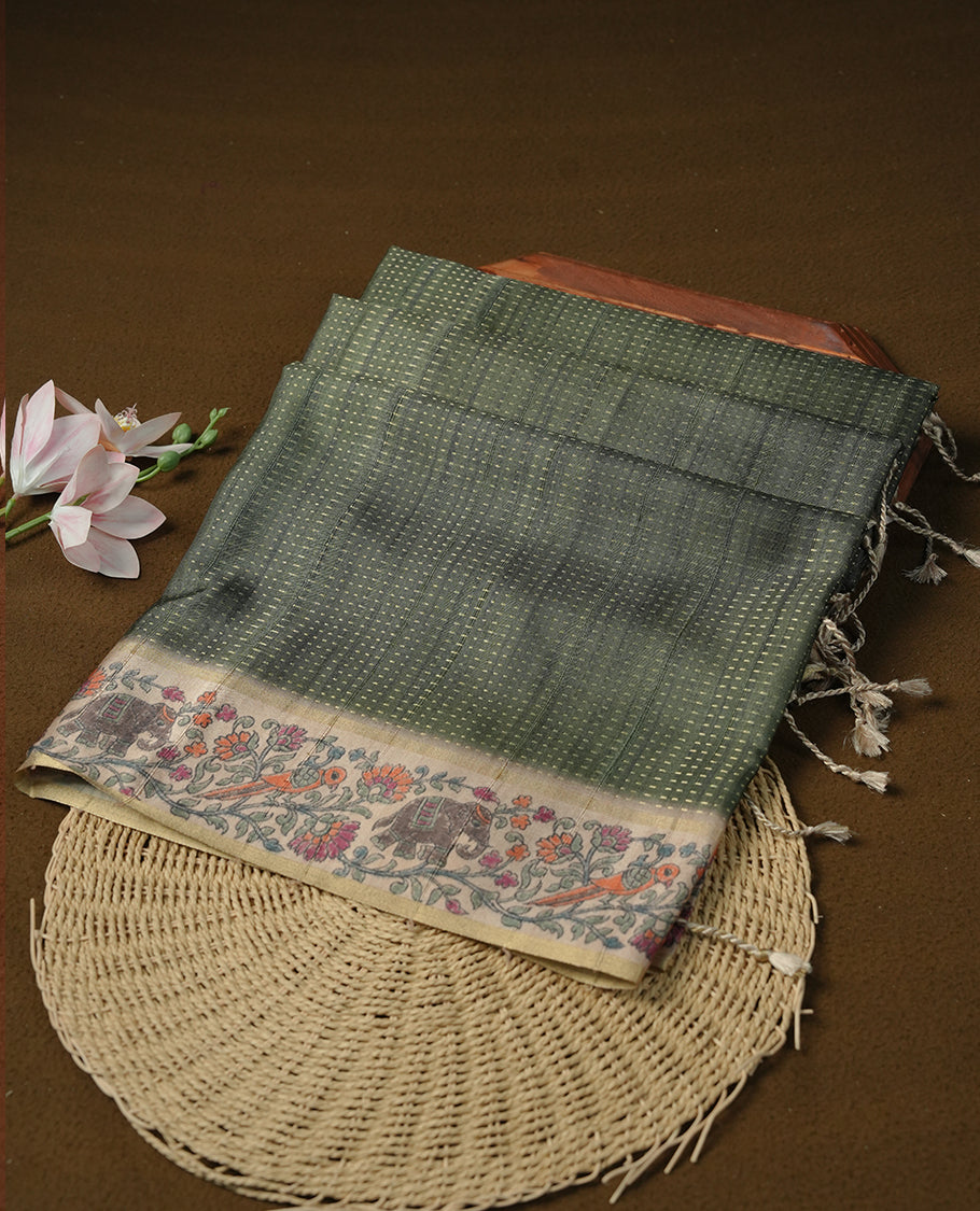 Castleton green colour tussar saree featuring golden zari dot stripped pattern on the body, complemented by a contrast cream colour mutlicolour floral kodi & animal print on border & pallu, paired with a matching blouse.