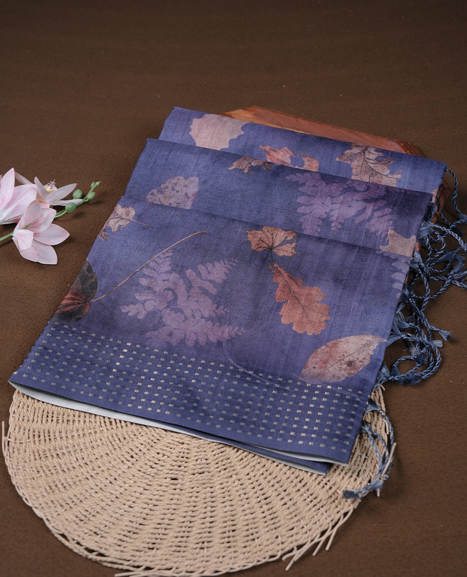 Dark blue colour tussar saree featuring woven Eco leaves printed on the body, complemented by a self colour gold zari bindi butta border & pallu, paired with a matching blouse.