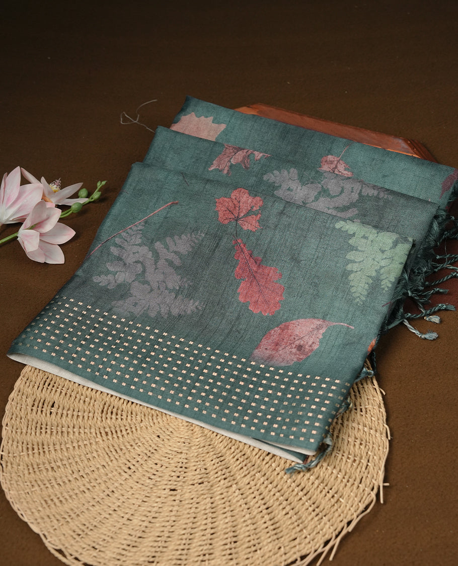 Dark green colour tussar saree featuring woven Eco leaves printed on the body, complemented by a self colour gold zari bindi butta border & pallu, paired with a matching blouse.