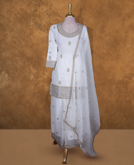 Off white colour sharara set featuring gold colour thread embroidered stone worked on neckline, sleeves, and thread scattered on body , Paired with a matching dupatta