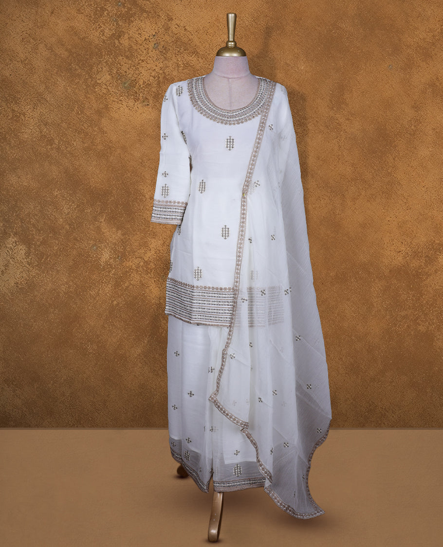 Off white colour sharara set featuring gold colour thread embroidered stone worked on neckline, sleeves, and thread scattered on body , Paired with a matching dupatta