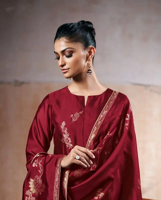 Wine Maroon colour suit material with pakiza silk top featuring delicate embroidery on the body and sleeves, paired with matching satin bottom and embroidered lace border dupatta.