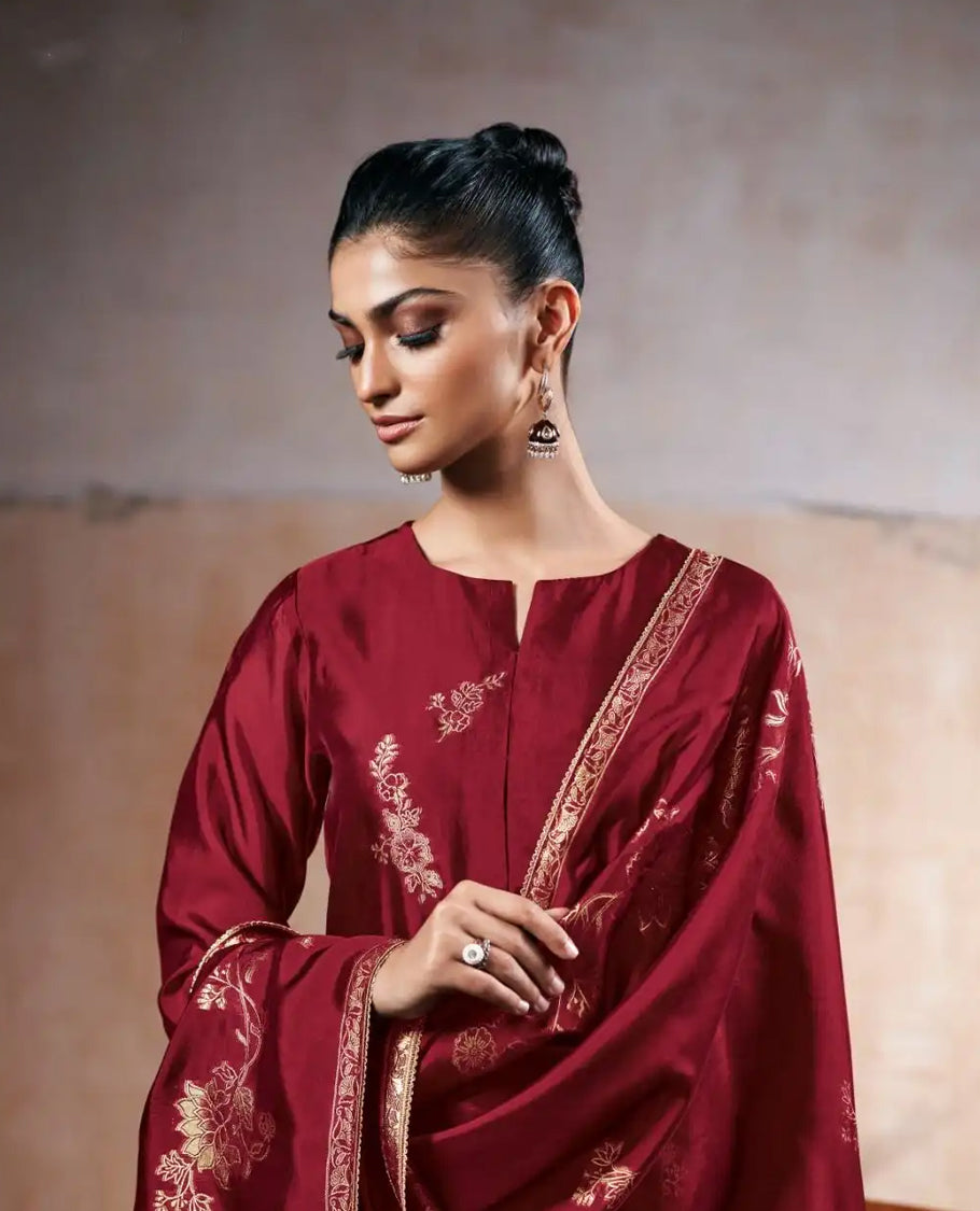 Wine Maroon colour suit material with pakiza silk top featuring delicate embroidery on the body and sleeves, paired with matching satin bottom and embroidered lace border dupatta.