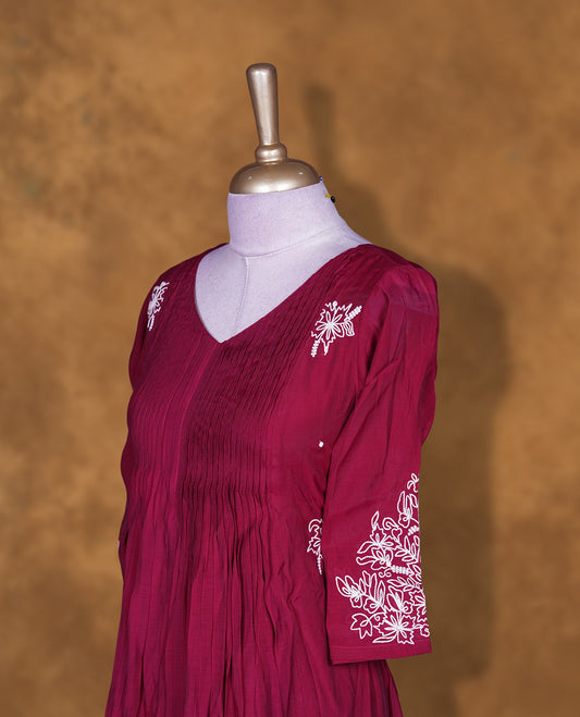 Wine colour embroidered kurti featuring a V-neckline with pintuck detailing, a calf-length silhouette, and three-quarter sleeves adorned with delicate floral thread work.