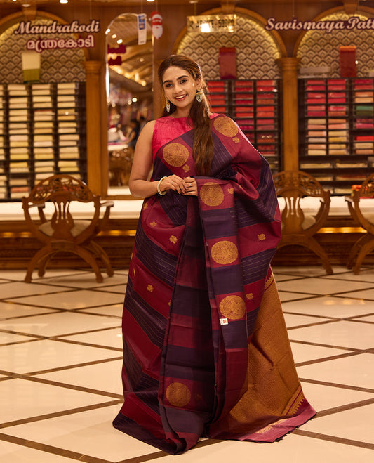 Graceful maroon and deep indigo colour kancheepuram silk saree adorned with classic gold zari polka motifs and elegant horizontal weaving, finished with a striking pallu and perfectly complemented by a blouse