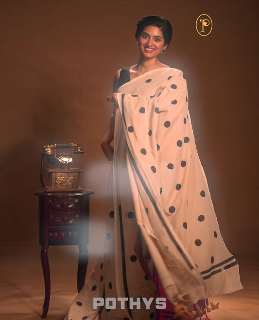 Beige colour Mul cotton saree featuring polka dot prints across the body, accented with a subtle small border, without a blouse piece.