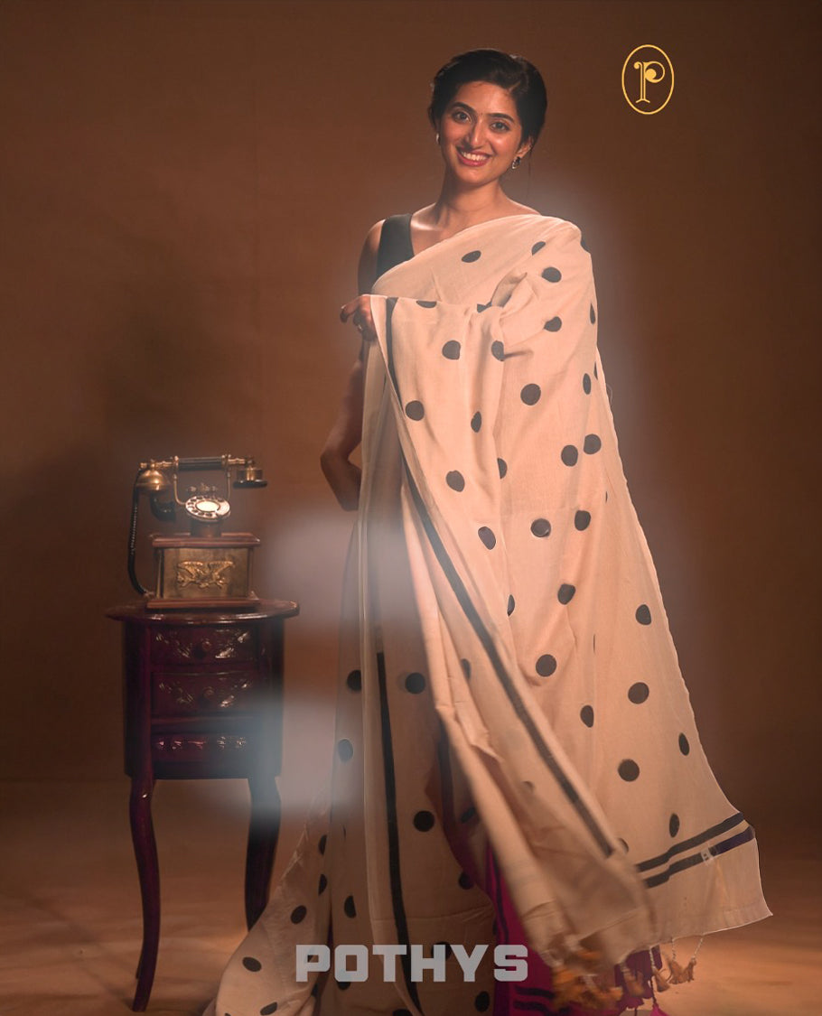 Beige colour Mul cotton saree featuring polka dot prints across the body, accented with a subtle small border, without a blouse piece.
