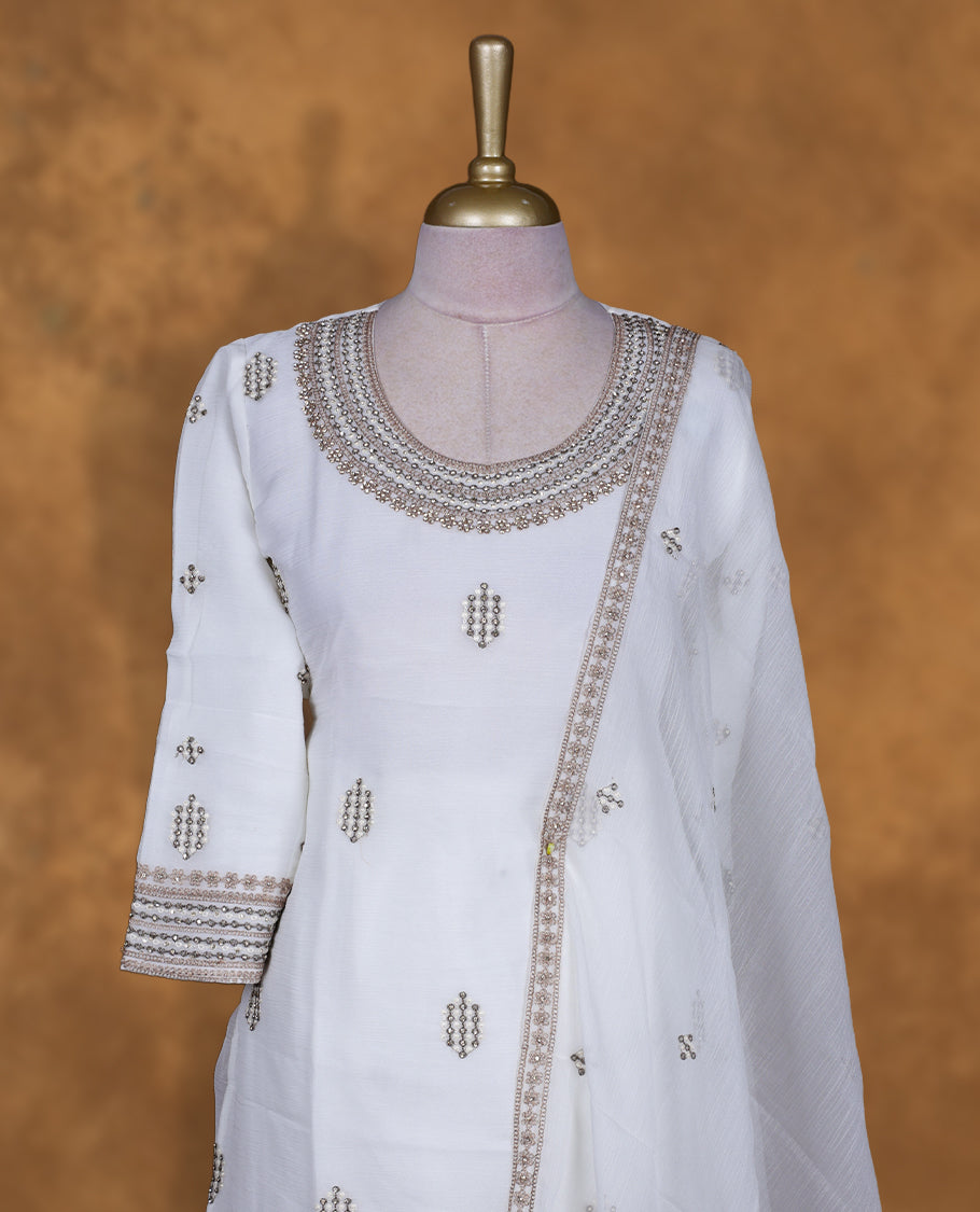 Off white colour sharara set featuring gold colour thread embroidered stone worked on neckline, sleeves, and thread scattered on body , Paired with a matching dupatta