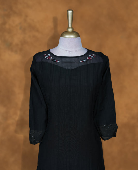 Black colour kurti featuring thread embroidery on neckline and sleeve, knee length design.