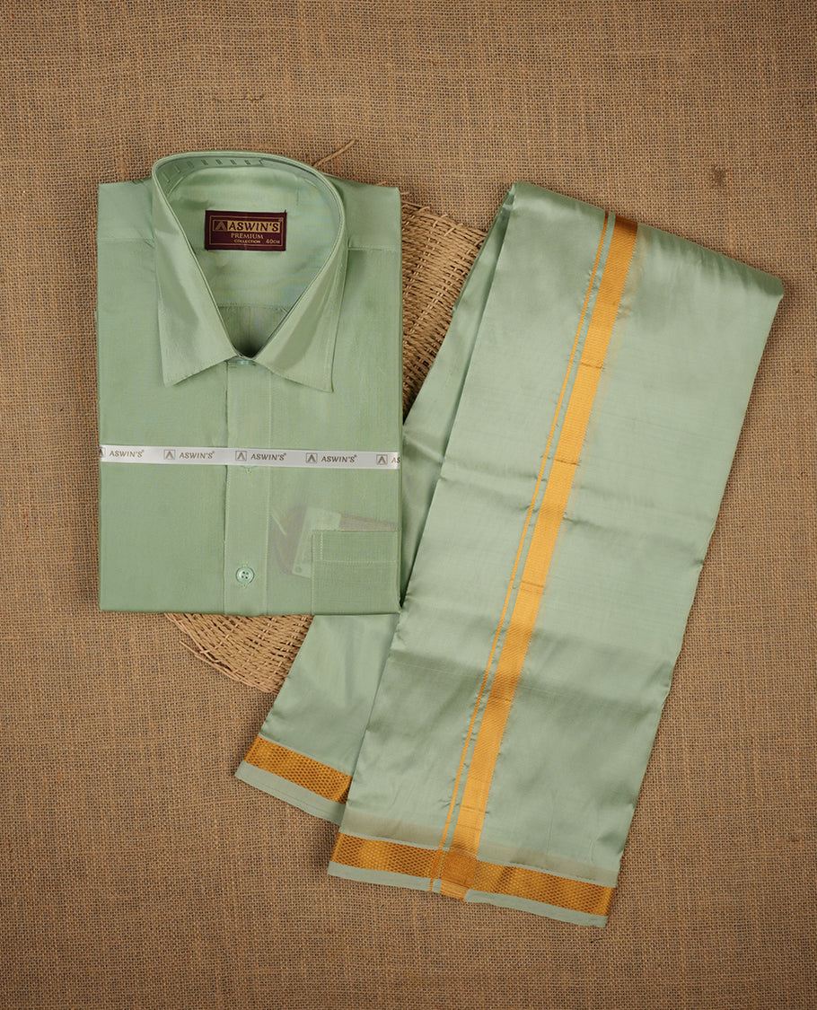 Pista colour shirt and dhoti with gold colour border, paired with matching colour silk saree featuring gold zari buttas and traditional border paired with matching blouse piece.
