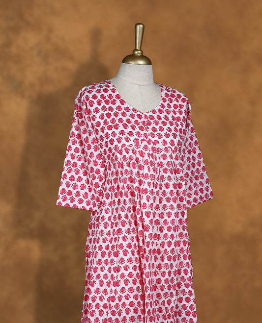 White colour Kurti featuring  pink floral print pattern across,  round neckline with botton detail, and sleeves,