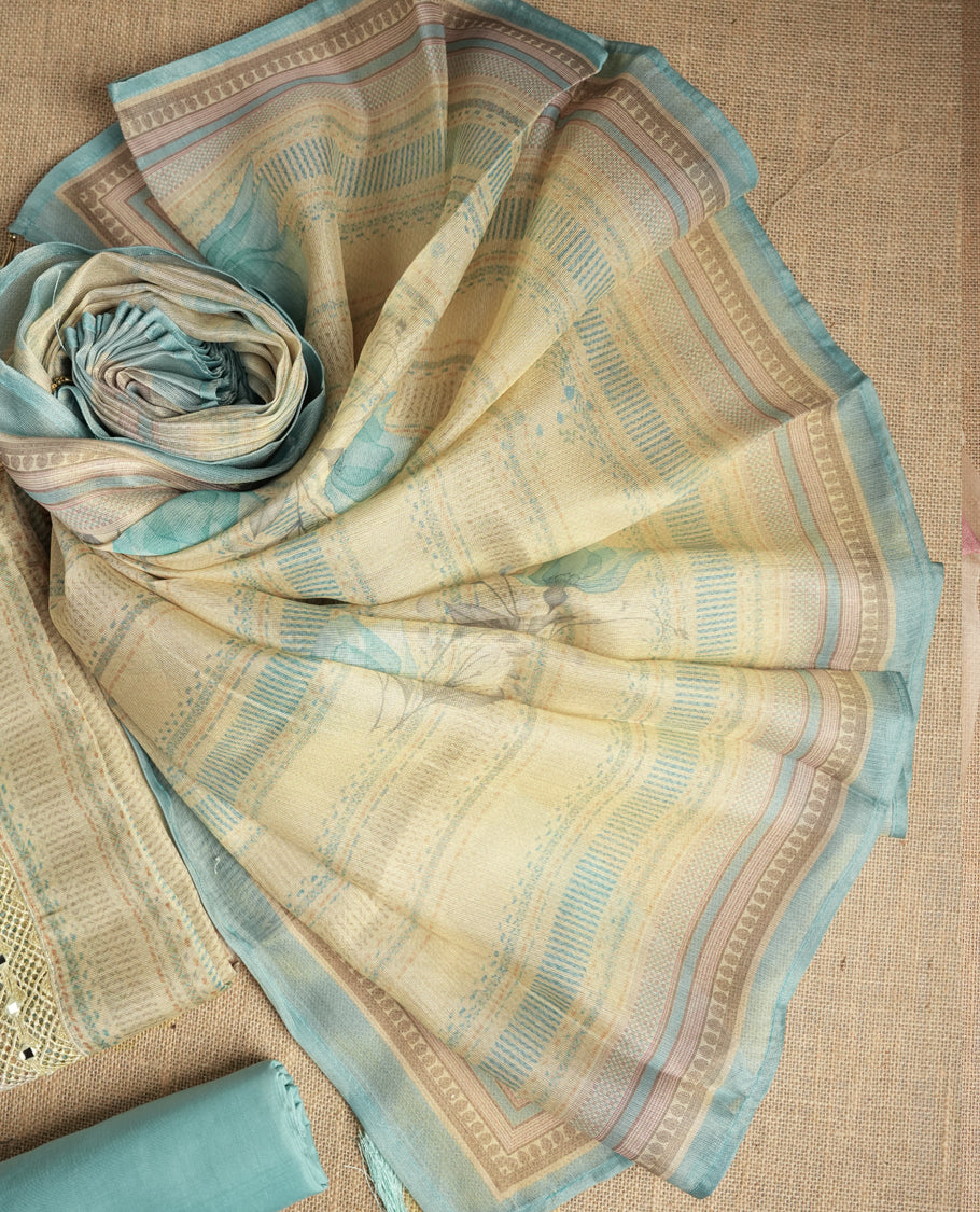 Sky blue and beige colour suit material with delicate woven mirror work patterns and subtle zari detailing & Includes a soft dupatta with a floral touch and plain matching bottom.