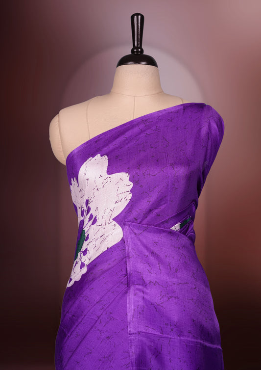 Purple colour saree highlighted with bold white floral prints, blending contemporary style with ethnic grace and paired with a matching blouse.
