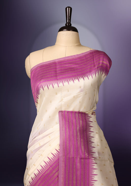 Off white colour saree adorned with delicate golden motifs, accentuated by a vibrant magenta border with intricate weaving, and a rich magenta gold zari pallu, paired with a matching blouse.