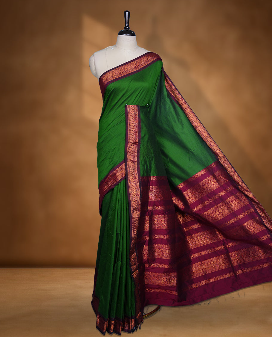 Green colour Kalyani cotton saree featuring a plain elegant body, complemented by a rich maroon zari border and traditional woven pallu, paired with a matching blouse.