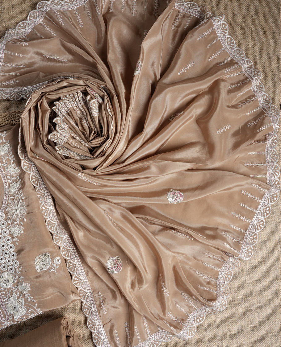 Beige colour suit material adorned with elegant white thread , cut beads & sequin embroidery, highlighted by a delicate lace border & Paired with a matching embroidered dupatta and plain bottom.