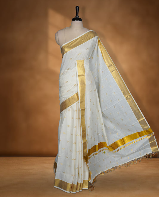 Off white colour cotton Kerala saree featuring a stripes and small buttas on body, a refined kasavu border, paired with a matching blouse.