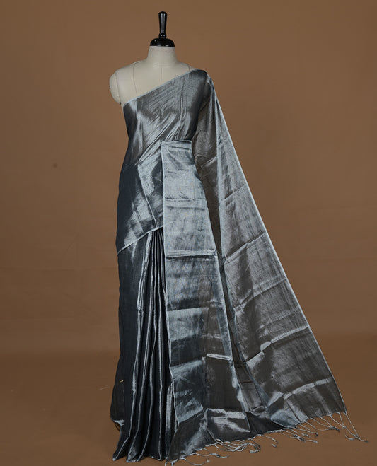 Silver colour semi tissue saree featuring an elegant plain body, designed without a border and comes without a blouse piece.