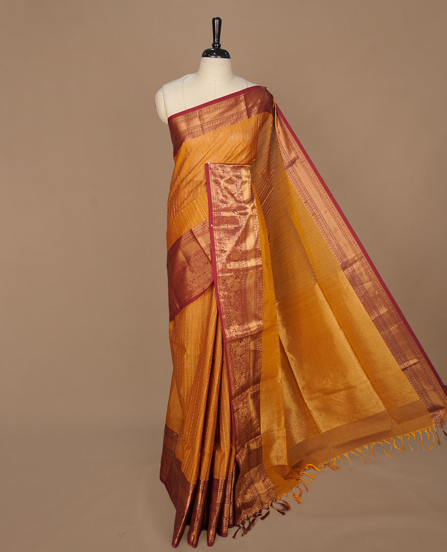 Mustard colour chettinad saree featuring gold zari stripes on body, complemented by contrast Maroon colour with traditional border, paired with matching blouse piece.