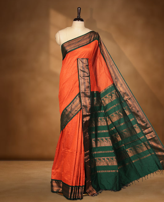 Burnt orange colour kalyani cotton saree featuring Antique zari check pattern on body, contrast Green colour border with antique zari pattern, paired with matching blouse piece.