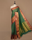 Green colour chettinad saree featuring gold zari stripes on body, complemented by contrast maroon colour with traditional border, paired with matching blouse piece.