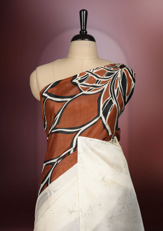 Brown and off white colour saree featuring bold abstract floral patterns, blending contemporary black colour design with ethnic elegance & paired with a matching blouse.